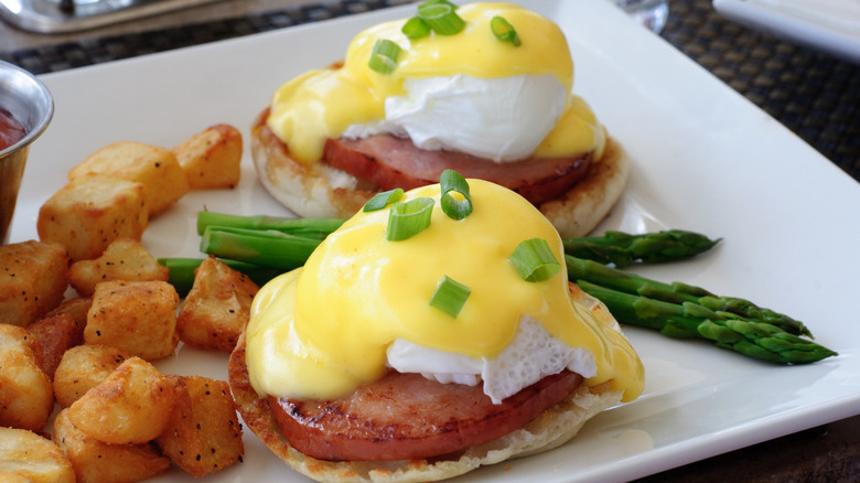 Eggs Benedict served with asparagus and potatoes