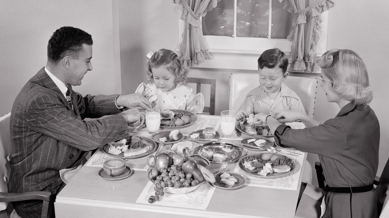A group of people from the 1950s eating a meal together.