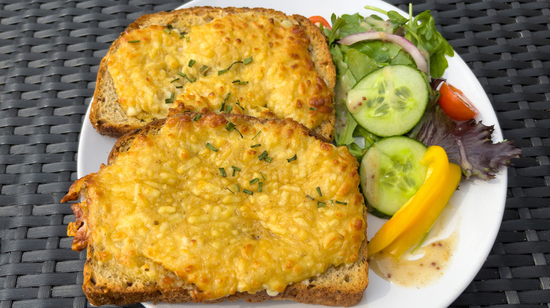 Two slices of Welsh rarebit with a side salad.