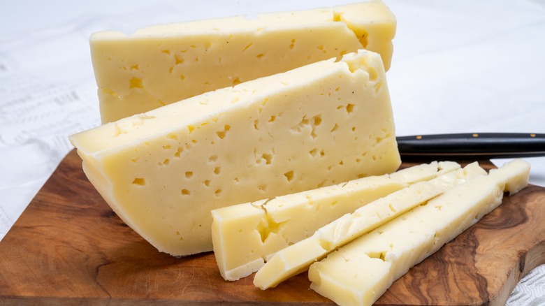 Sliced Asiago on wooden board