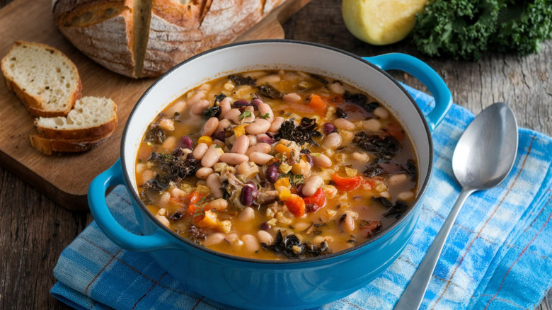Blue enamel dish of Tuscan soup la ribollita with bread in background