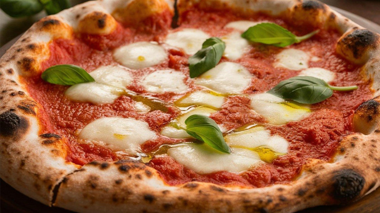 authentic pizza Margherita with tomato paste, melted mozzarella and basil leaves