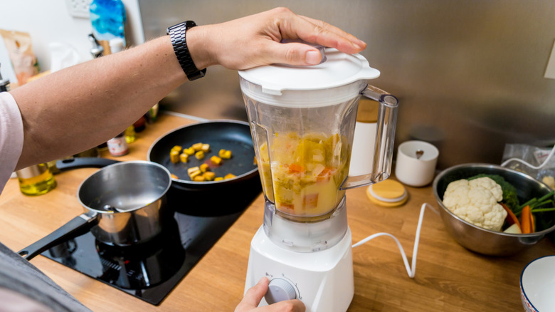 a chunky soup being blended in a blender.