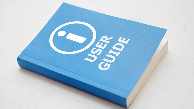 a generic blue book labeled user guide with an i in a circle.