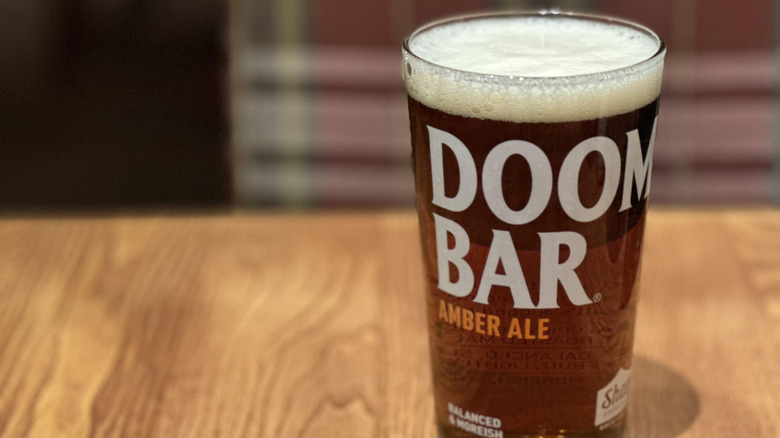 Branded pint glass on a wood tabletop.