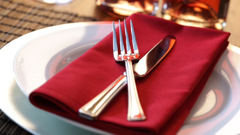 Silverware on a red napkin.