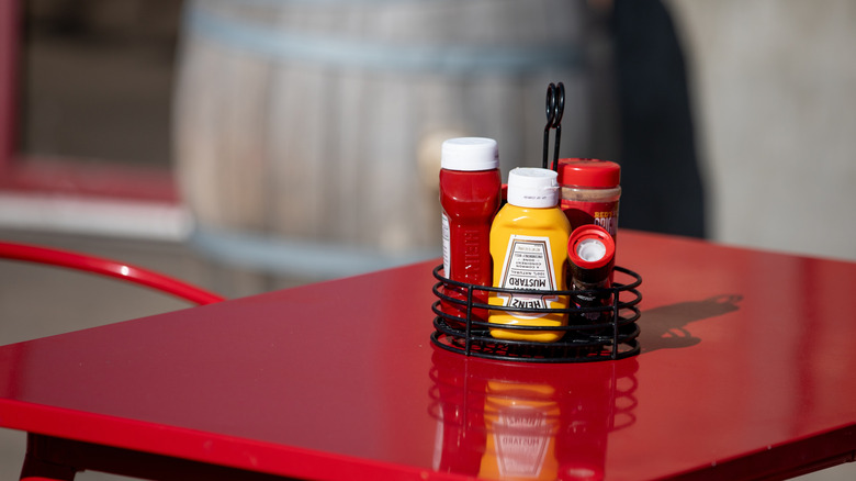 Condiments on a table caddy at a restaurnt.