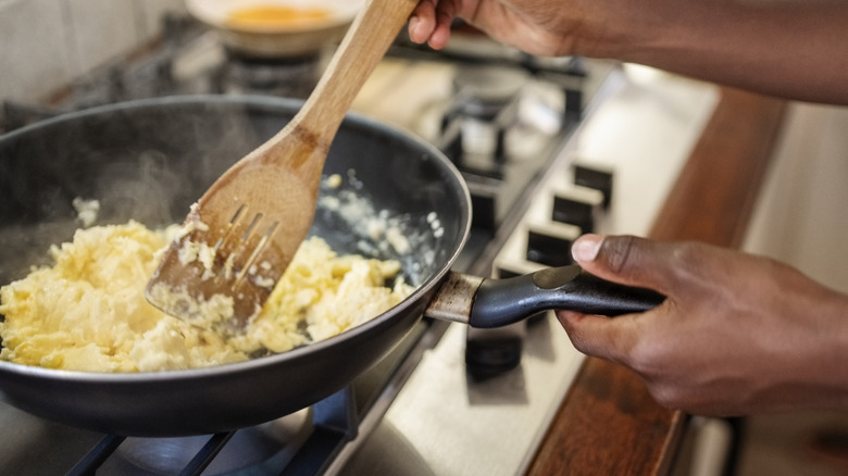 Person preparing scrambled eggs