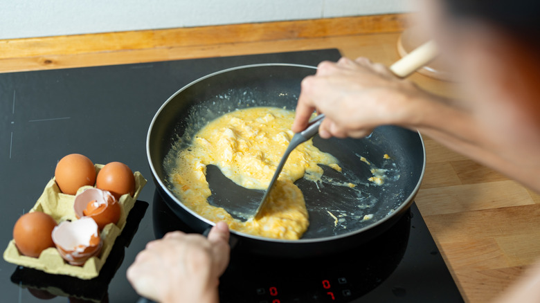 Woman making scrambled eggs