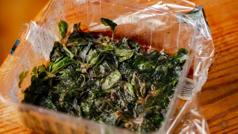 Slimy, spoiled leafy greens in plastic packaging