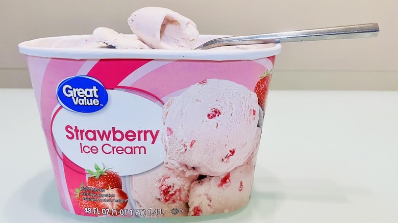 Opened carton of Great Value Strawberry Ice Cream with spoon on top