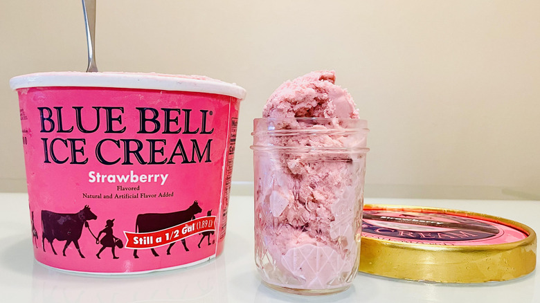Full glass and open carton of Blue Bell Strawberry Ice Cream