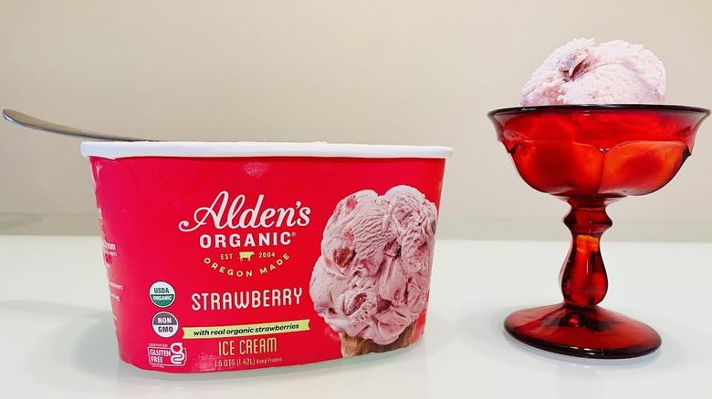 Red dish of Alden's Organic Strawberry Ice Cream with carton on side