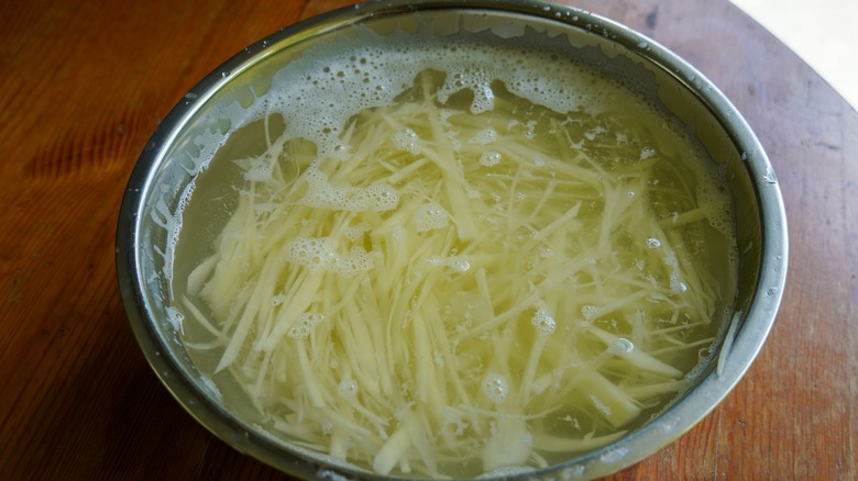 shredded potatoes soaking in water