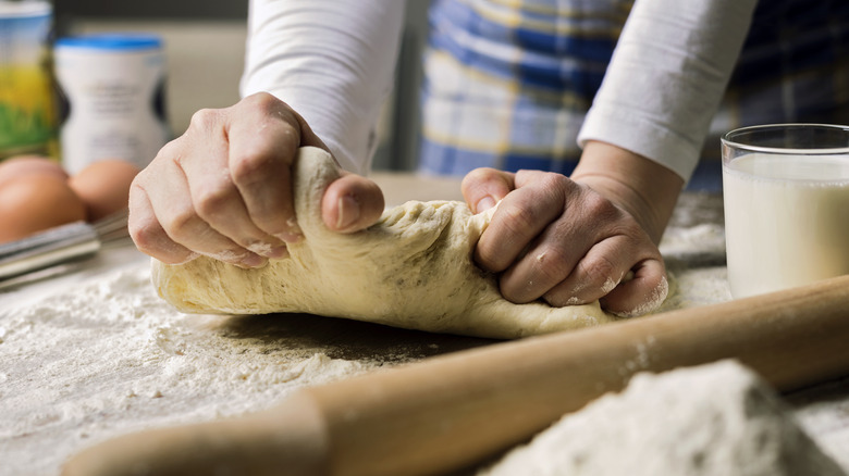 person kneading dough