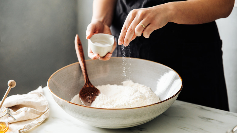 person adding enhancer to dough