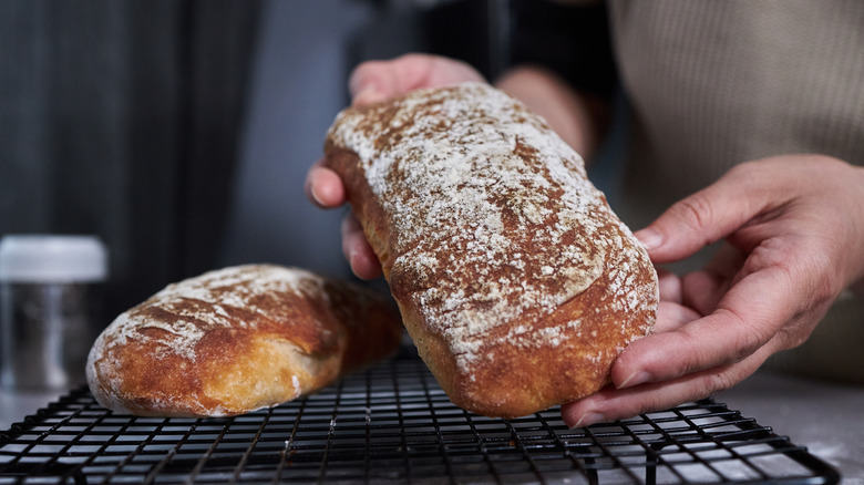 person placing bread on rack
