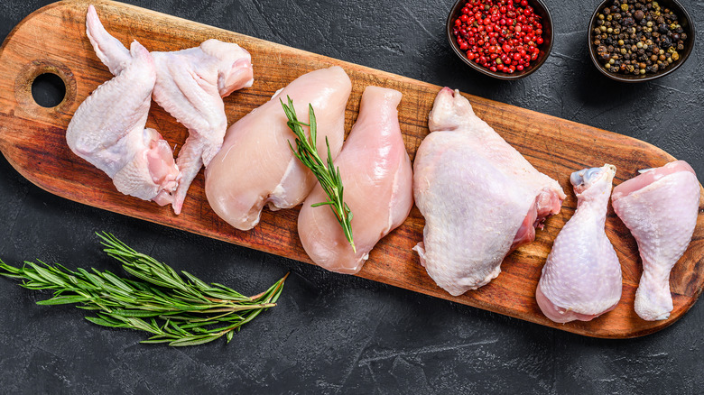 Raw cuts of chicken on board
