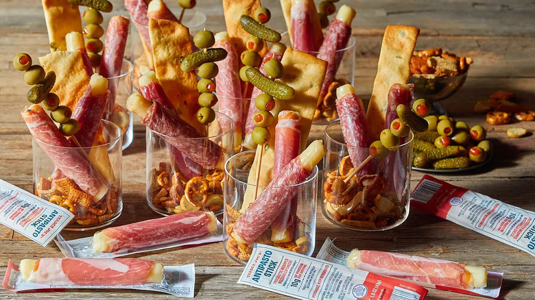 Antipasto Sticks of prosciutto-wrapped mozarella sit in cups with olives and cheese crisps