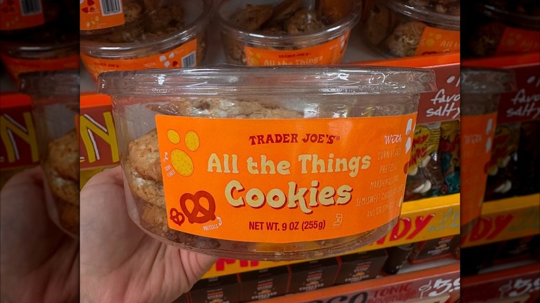 A side view of a tub of All the Things Cookies in front of a display of the cookies