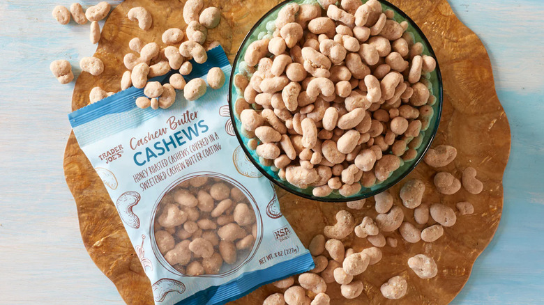 A bag of Trader Joe's Cashew Butter Cashews sits beside a bowl of the nuts