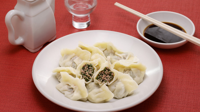 bowl of dumplings with black vinegar on the side