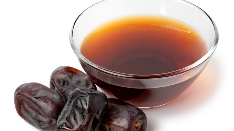small bowl of date vinegar with whole dates on the side