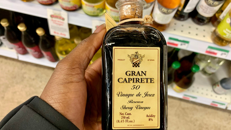Bottle of Gran Capirete reserva Sherry vinegar in a man's hand