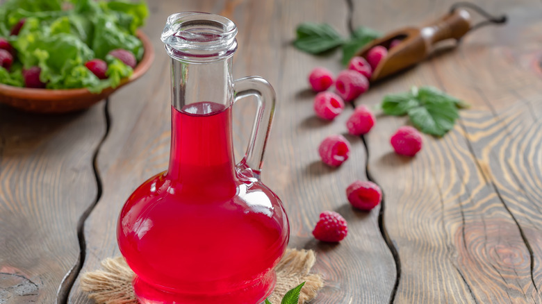 bottle of raspberry vinegar with raspberries in background