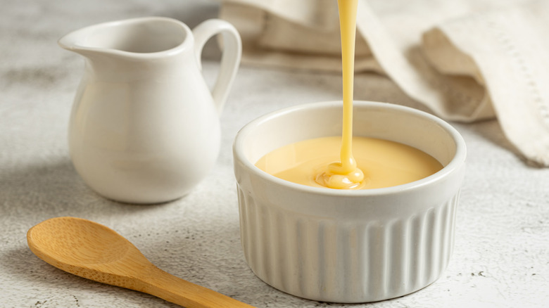 Condensed milk being poured in a ceramic bowl