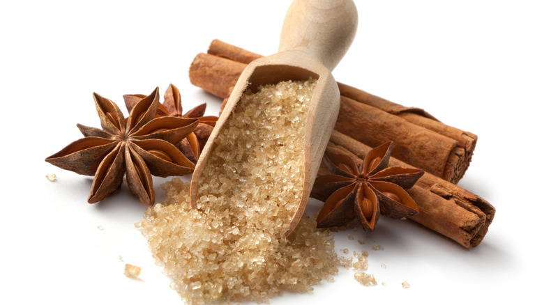 a scoop of sugar, two cinnamon sticks, and anise stars