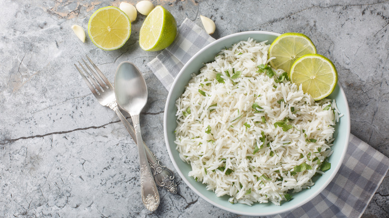 Bowl of white rice with fresh lime, garlic, and cilantro