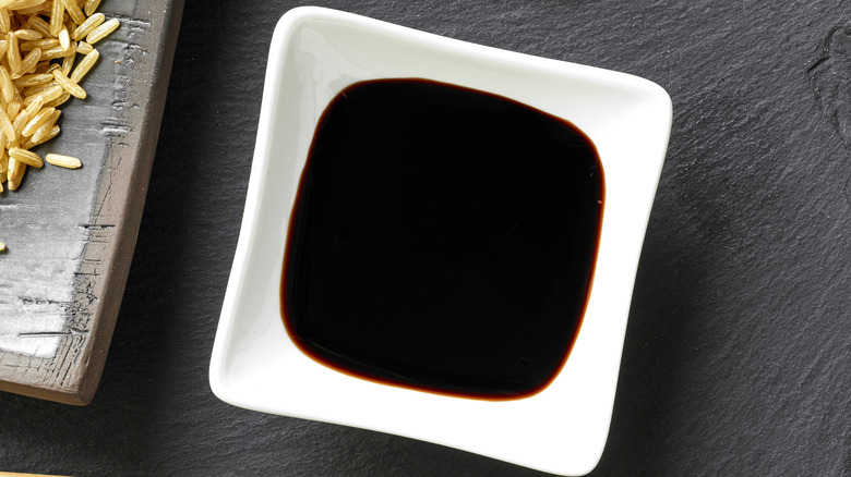 Overhead view of a square dish full of soy sauce
