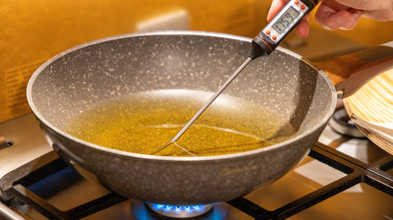 Taking temperature of frying oil with digital thermometer