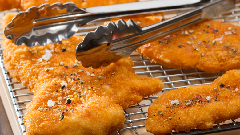 Fried chicken tenders resting on a wire rack