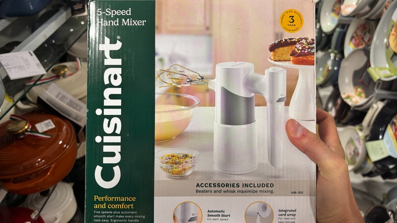 A person is holding a 5-speed mixer in its box.