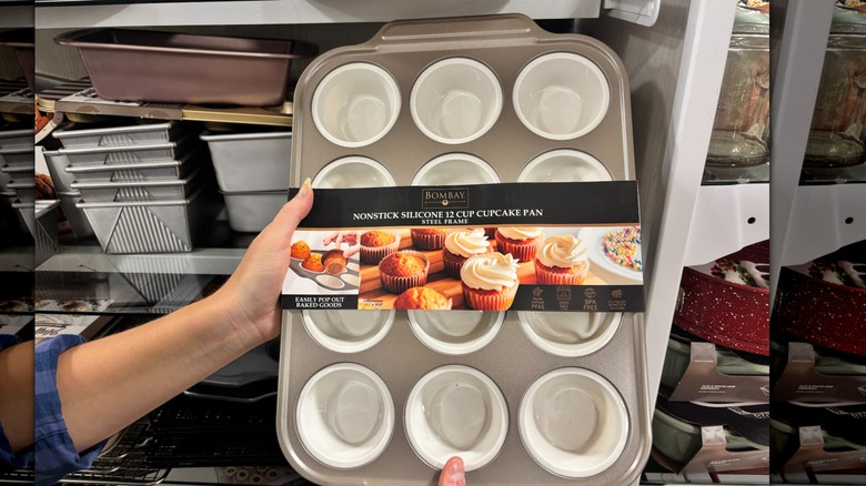 A person is holding a non-stick silicone cupcake tray in HomeGoods