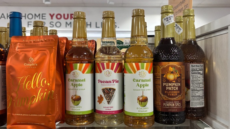 A store shelf is full of different seasonal syrup flavors.