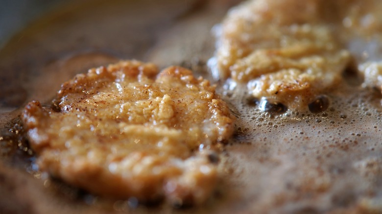 Abalone steaks sizzling in a pan