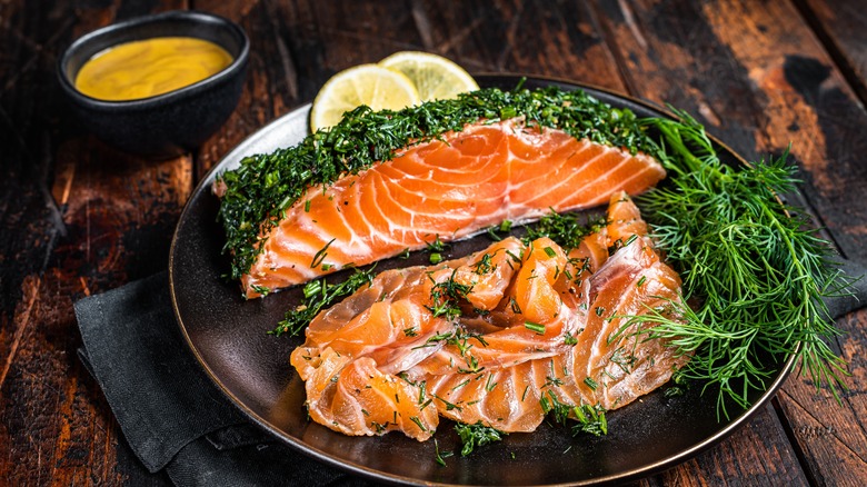 Gravlax on a dark borown plate with dill