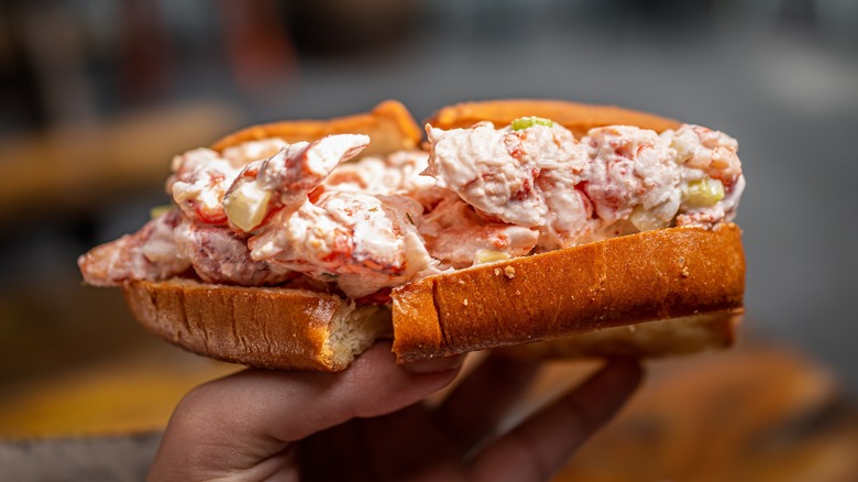 Maine lobster roll being held up in a hand