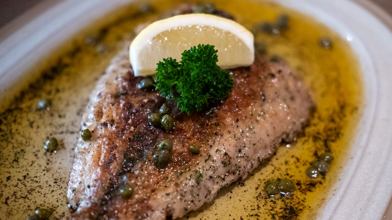 Sole à la meunière on a white plate with beurre noir and capers
