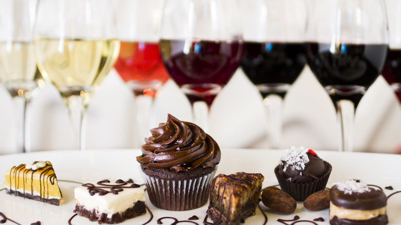 set of various wines in glasses behind a set of desserts