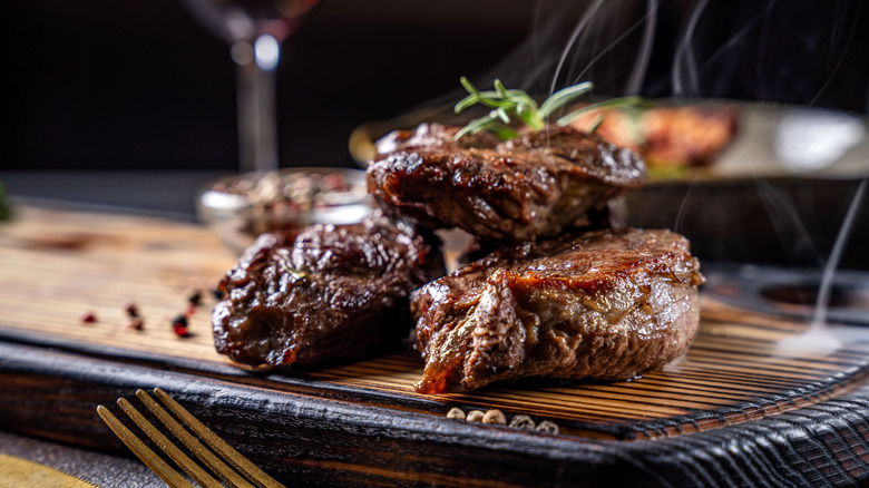 close up shot of cooked beef steak slabs on wooden board