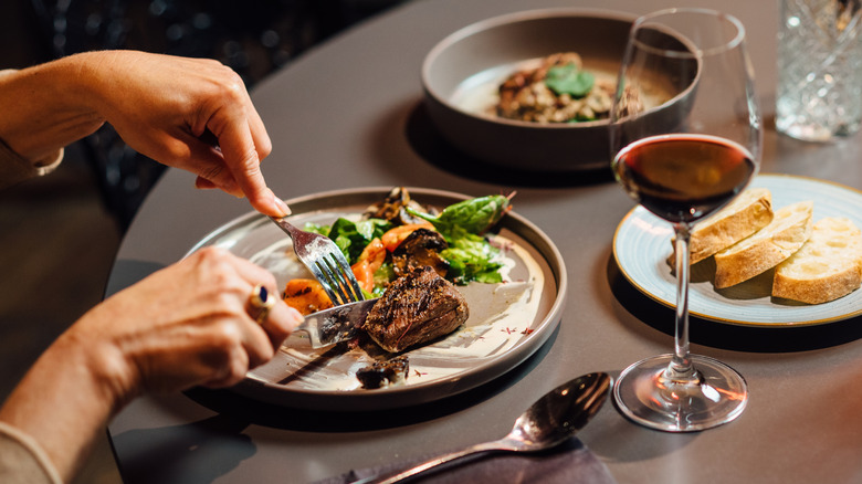 fine dining scene at table with gourmet meal and red wine