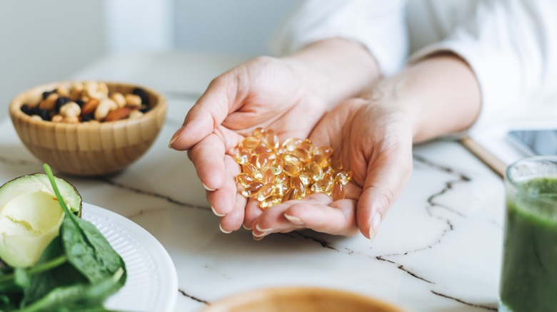 woman holding omega-3 capsules