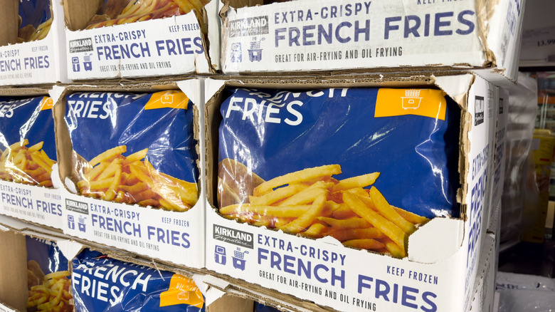 several bags of kirkland signature extra crispy french fries on display at costco