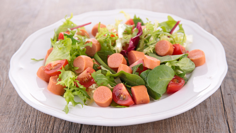 Green salad with sliced hot dogs