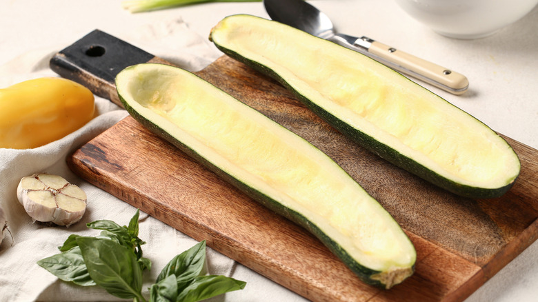 Hollowed-out zucchini boats on a cutting board
