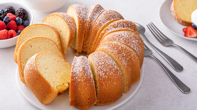 Pound cake topped with powdered sugar on a white serving plate